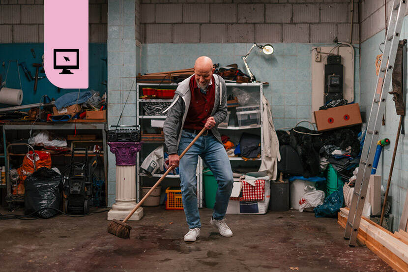 Een man veegt zijn garage aan, waar duidelijk net de vloer vrij is gekomen nadat daar lang iets heeft gestaan.